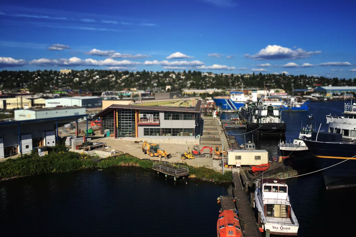 A building near a harbor being constructed with a green roof.